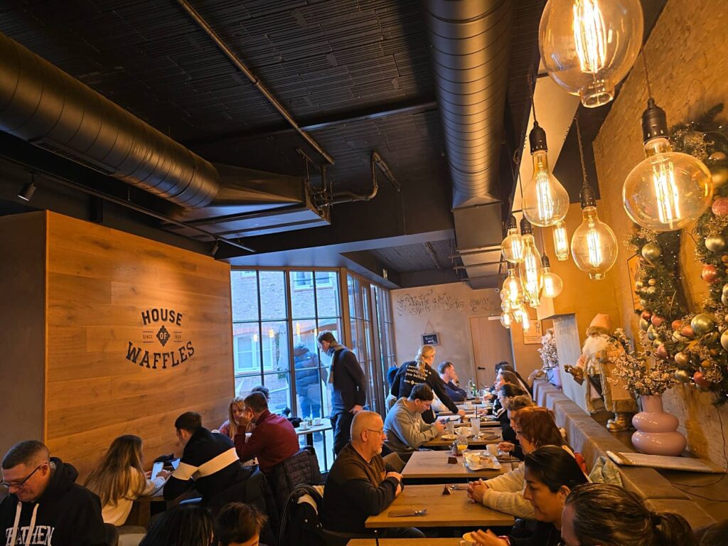 Interno accogliente di House of Waffles a Bruges con posti a sedere per famiglie