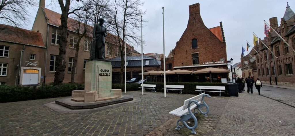 Cosa vedere a Bruges: guida completa alla perla delle Fiandre che ti ruba il cuore 85 statua guido gezelle nella piazza davanti alla chiesa di nostra signora